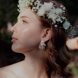 Side profile of a bride with a wildflower crown wearing the Cobweb sculpted organic metal and pearl cluster earrings.